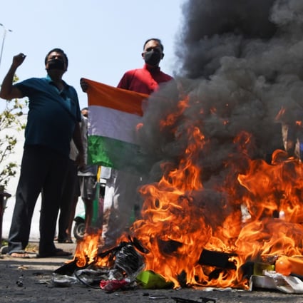 Anti-China protesters hold the Indian national flag as they burn Chinese products during a demonstration in New Delhi on June 18. Photo: AFP