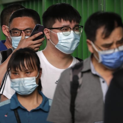 Commuters wearing protective face masks to help curb the spread of the new coronavirus line up to board a bus at a bus terminal in Beijing on June 22, 2020. Beijing acted swiftly when the virus broke out again recently and says it is under control.