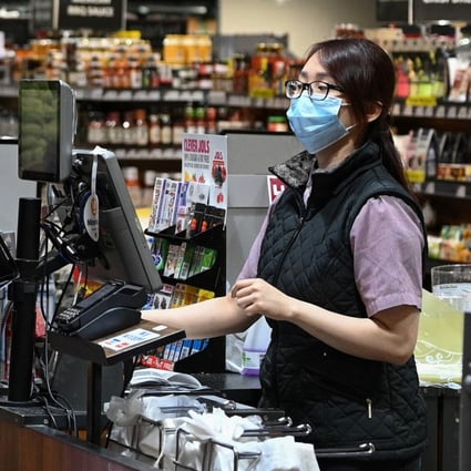 A cashier wears a face mask while serving a customer in Sydney on June 17, 2020. Photo: Reuters