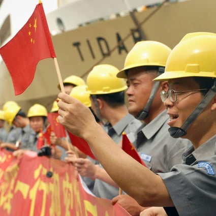 Workers wave Chinese flags during China Vice-Premier Li Keqiang’s visit to the Suramadu bridge in Surabaya, East Java, on December 21, 2008. File photo: AFP