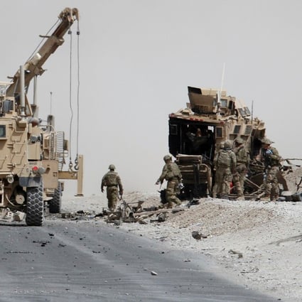 US troops assess the damage to an armoured vehicle of NATO-led military coalition after a suicide attack in Kandahar province, Afghanistan. Photo: Reuters