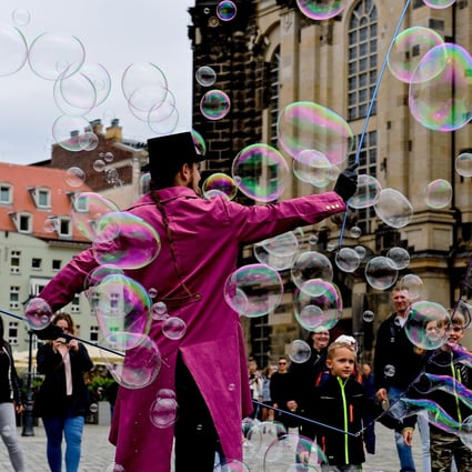 A street artist makes giant soap bubbles on Neumarkt square in Dresden, Germany, on May 31 as tourism restarts with the easing of lockdowns. Photo: EPA-EFE