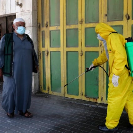 A health department worker of the Palestinian Hebron Municipality sterilises a street. Photo: AFP