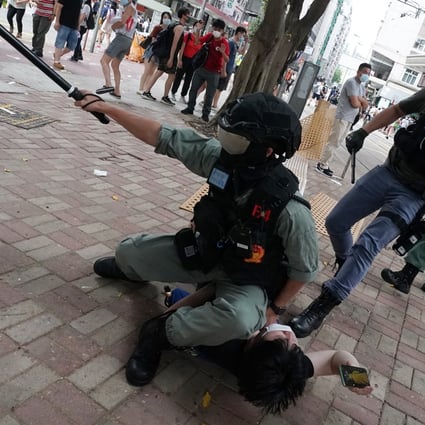 A police officer holds down an anti-government protester in Wan Chai on Wednesday. Photo: Felix Wong