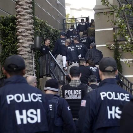 Federal agents enter an upscale flat complex in Irvine, California during a raid in 2015. File photo: AP