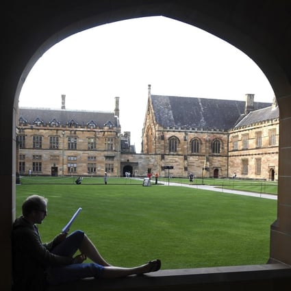 A student reads while sitting on a ledge at the Quadrangle of the University of Sydney, Australia. Photo: AP
