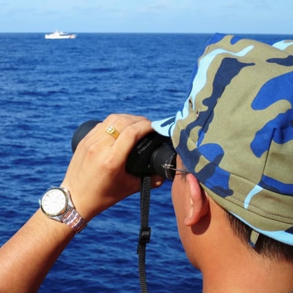 A Vietnamese coastguard ship crew member looks at Chinese coastguard vessels in the South China Sea. China is conducting military drills in the disputed sea. File photo: Reuters