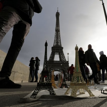 Tourists walk near the Eiffel tower in Paris. The travel and tourism industry is one of the most severely hit sectors by the Covid-19 pandemic. Photo: Reuters