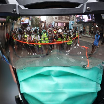 Journalists are reflected in a riot officer’s visor while covering a protest against Hong Kong’s national security law on July 1. Concerns are growing among local media figures that elements of the new law could constrain traditional press freedoms in the city. Photo: Xiaomei Chen