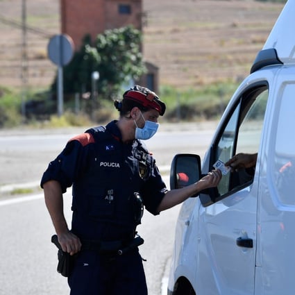 A member of the Catalan regional police force Mossos d'Esquadra controls a checkpoint on the road leading to Lleida. Photo: AFP