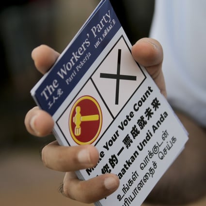 A member of Singapore’s Worker's Party handing out flyers before the elections. Photo: EPA