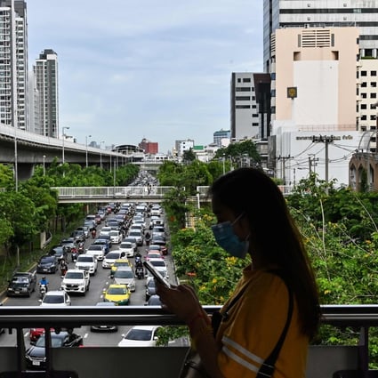 A pedestiran walks through Bangkok during peak hour. Photo: AFP