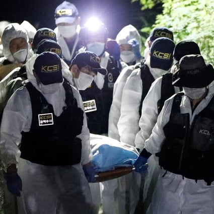 Police officers carry the body of Seoul Mayor Park Won-soon out of the woods at Mt Bugak. Photo: Reuters