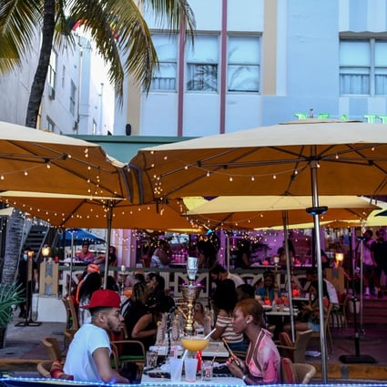 A couple enjoy drinks at a restaurant on Ocean Drive in Miami Beach, Florida, on June 26. Patrons flocked to restaurants and entertainment venues after the state eased restrictions to curb the spread of Covid-19, but Florida is now seeing a surge in case numbers. Photo: AFP