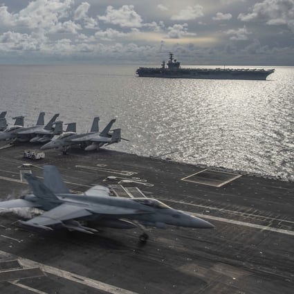 An F/A-18E Super Hornet lands on the flight deck of the USS Ronald Reagan as the USS Nimitz steams past in the South China Sea on July 6. Photo: US Navy via AP