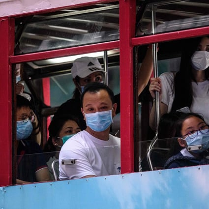 Commuters wear face masks as they travel on the top deck of a tram in Hong Kong on July 10. The emergence of a third wave of Covid-19 infections has led to renewed calls for social distancing and working from home. Photo: AFP