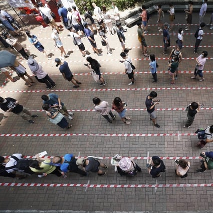 People queue up to vote at a polling station outside Tai Po Plaza in Tai Po on Sunday. Photo: Felix Wong
