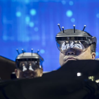 Visitors wearing virtual reality (VR) headsets try a driving system at a Nissan Motors booth during CES Asia in Shanghai on June 11, 2019. Photo: Bloomberg