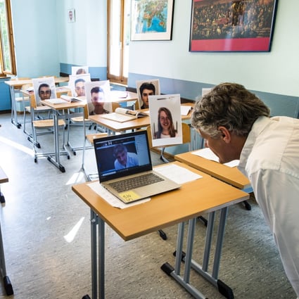 Online tutor Christophe Blanc gives an economics lesson in front of pictures of his students in Switzerland on April 29. Stay-at-home measures to prevent the spread of Covid-19 have increased international demand for remote learning. Photo: EPA-EFE