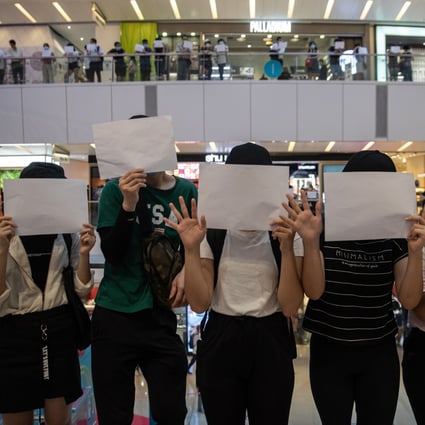 Protesters hold sheets of white paper during a protest in a Hong Kong shopping mall, on July 6. Photo: EPA-EFE