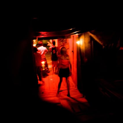 A prostitute walks into a brothel in Phnom Penh, Cambodia. It was in Phnom Penh that Malaysian comic book artist first saw young children walking the streets looking for customers. Photo: Getty Images