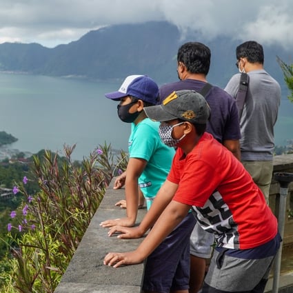 Visitors wearing face masks admire the scenery at Lake Batur in Indonesia. Indonesia’s tourism industry is looking at ways of luring visitors back to the country. Photo: SOPA Images/LightRocket via Getty Images