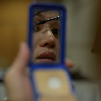 A transgender Malaysian woman puts on make-up. Photo: AFP