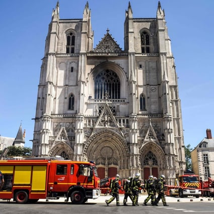 Firefighters are seen at the Cathedral of St Peter and St Paul in Nantes after a fire ravaged parts of the Gothic building on July 18. A man has been questioned after police opened an arson probe. Photo: AFP