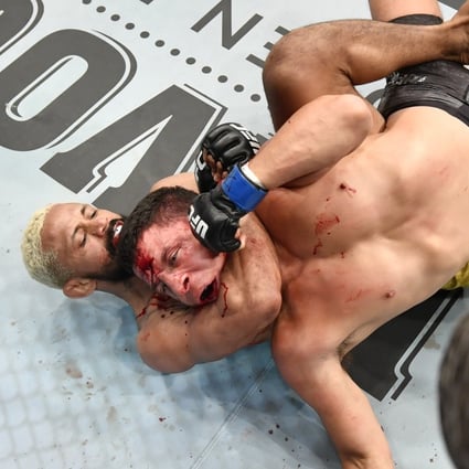 Deiveson Figueiredo secures a rear-naked choke submission against Joseph Benavidez in their UFC flyweight championship bout during the UFC Fight Night event inside Flash Forum on UFC Fight Island in Abu Dhabi. Photos: Jeff Bottari/Zuffa LLC via Getty Images