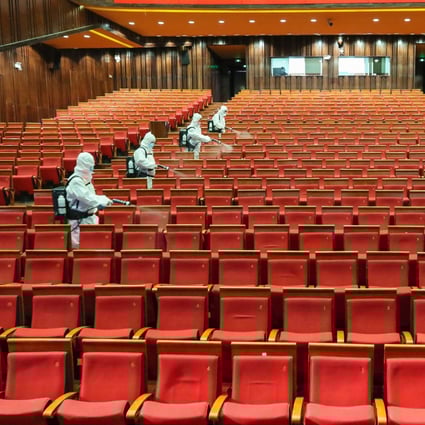 Staff members spray disinfectant at a theatre on May 12 as it prepares to reopen in Yantai, a city in China's eastern Shandong province. Photo: AFP