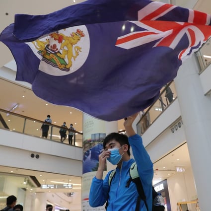 An anti-government protester waves the flag of colonial-era Hong Kong during a protest in a shopping mall on June 8. Photo: Sam Tsang