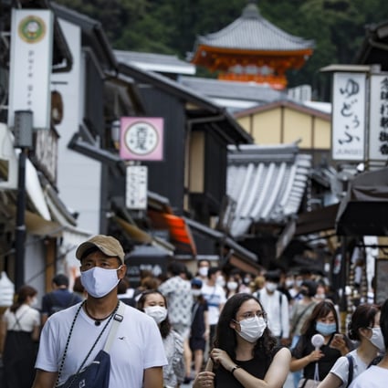 Japanese wearing face masks walk near Kiyomizudera temple in Kyoto. Thousands of tourists flocked to the ancient capital as the country's domestic tourism campaign started, despite concerns about record new Covid-19 cases. Photo: EPA-EFE