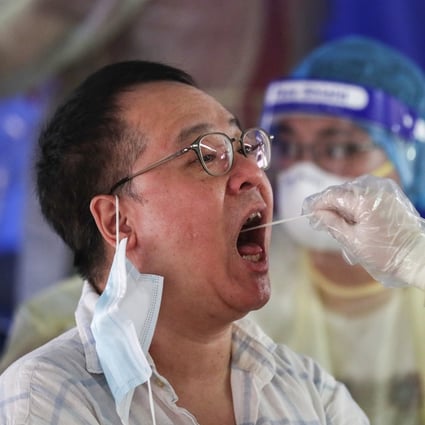 A medical worker takes a swab from a taxi driver at a makeshift testing station for coronavirus in a carpark on July 20. Photo: SOPA Images via ZUMA Wire/dpa