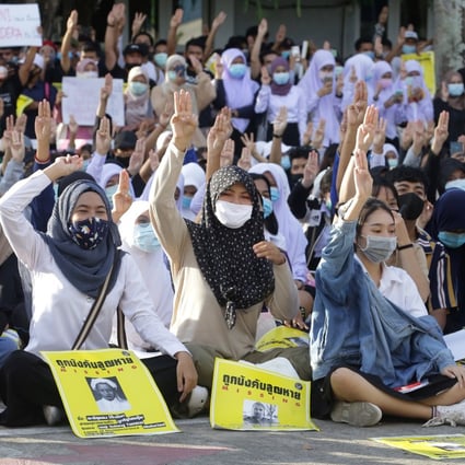 Thai protesters make the three-fingered Hunger Games salute. Photo: AFP