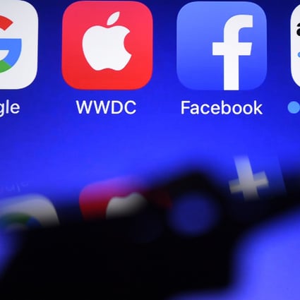 A smartphone being operated in front of GAFA logos (acronym for Google, Apple, Facebook and Amazon). Photo: AFP