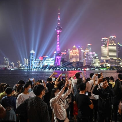People wearing face masks to guard against the coronavirus visit the promenade on the Bund along the Huangpu River in Shanghai on May 1, when tourist sites reopened for an extended May Day national holiday in a test of post-coronavirus confidence. Photo: AFP