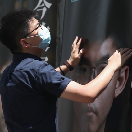 Joshua Wong sets up campaign posters during the opposition camp’s recent primary election. Photo: Xiaomei Chen