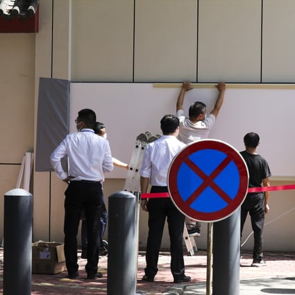 Workers start to cover the name of the US Consulate General in Chengdu with white board on July 27, after Beijing closed it in retaliation against the Houston closure. Photo: Simon Song