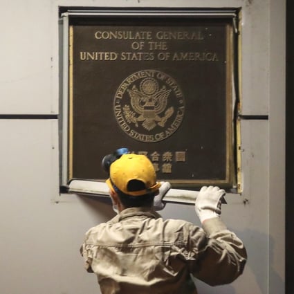 Workers remove a plaque marking the US consulate in Chengdu on Sunday night after the office was closed as part of a diplomatic row. Photo: Simon Song