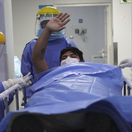 A patient waves goodbye to other patients as he is taken out of the intensive care unit for Covid-19 cases in Lima, Peru. Photo: AP