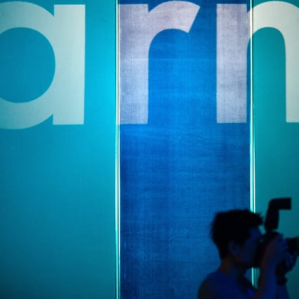 A photographer is seen in front of the logo of British chip design company Arm in Taipei on May 27, 2019. Photo: Agence France-Presse