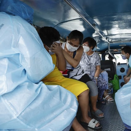 Health workers collect blood samples inside a jeepney bus at a free Covid-19 drive-thru testing facility in Manila. Photo: AP