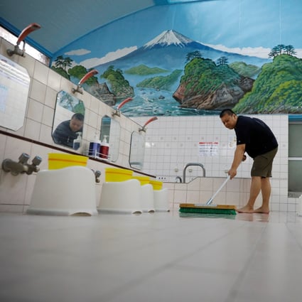 Takuya Shimbo, the third-generation owner of public bathhouse Daikoku-yu, cleans the floor before its daily opening amid the coronavirus disease pandemic in Tokyo. Photo: Reuters