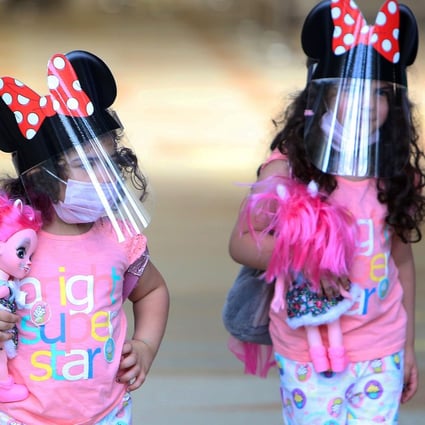 Children travelling from Kuwait international Airport, wear face masks and shields as protections against the novel coronavirus. Photo: AFP