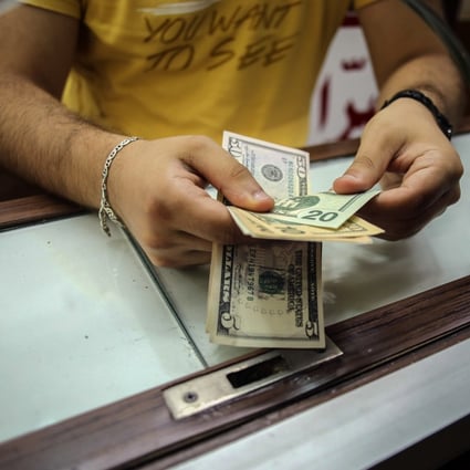 A worker at a currency exchange bureau handles US dollar banknotes in Beirut, Lebanon, on July 21. The dollar is universally accepted for transactions, portfolio investment and speculation. It is without parallel as a multipurpose all-rounder. Photo: Bloomberg