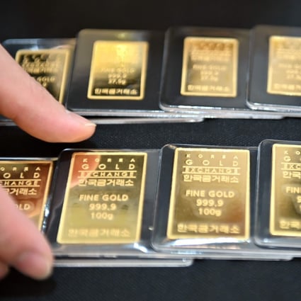 An employee displays gold bars at a Korea Gold Exchange shop in Seoul on July 30. Virus uncertainty and China-US tensions have sent gold prices soaring nearly 30 per cent this year. Photo: AFP