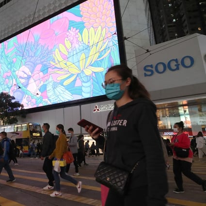 Shoppers in protective masks cross the road in front of the Sogo department store in Causeway Bay. Photo: Edmond So