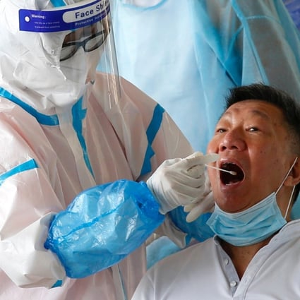 A swab sample is collected from a taxi driver by a Covid-19 health worker in Hong Kong last month. Photo: Reuters