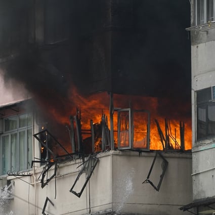 A fourth-floor flat burns inside Sham Shui Po’s Dai Un Building, prompting residents to evacuate the premises. Photo: Felix Wong