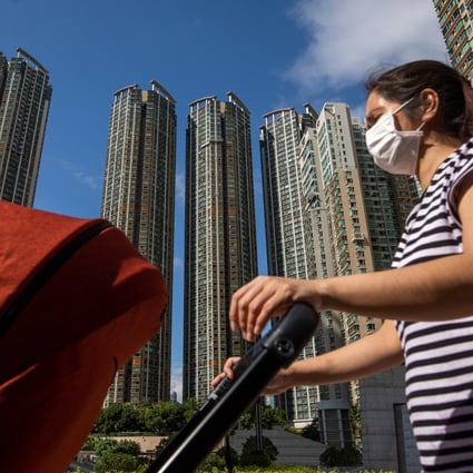 A person wearing a protective mask pushes a stroller past residential buildings near the West Kowloon station in Hong Kong, China, on Wednesday May 6, 2020. Photo: Bloomberg